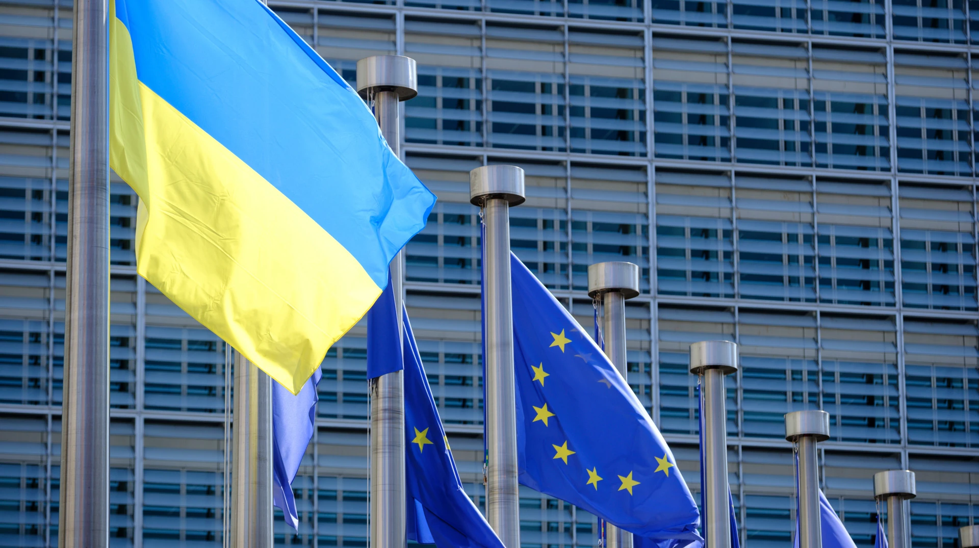 Логотип Єврокомісії на тлі прапорів ЄС та України